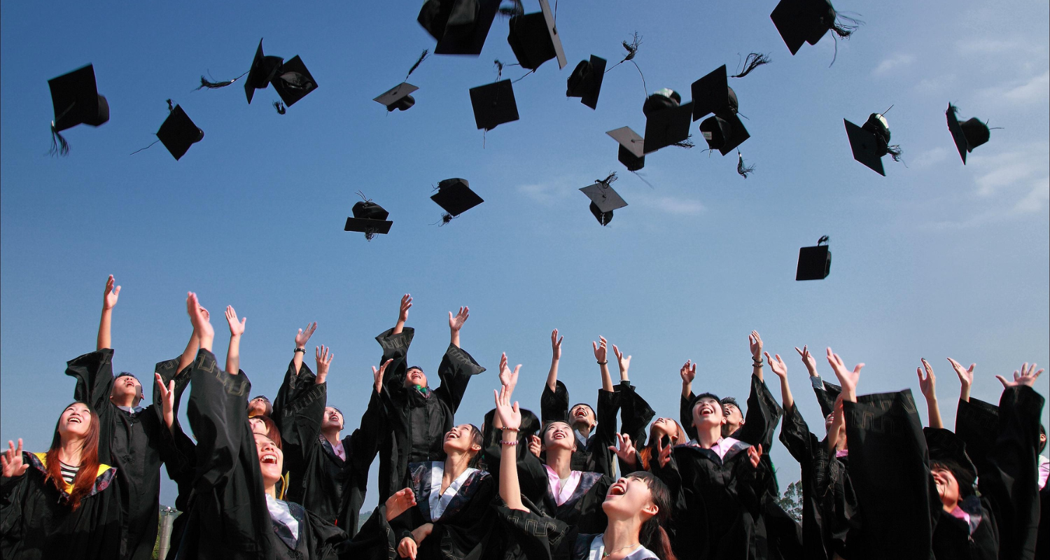 College graduates tossing graducation caps into the air